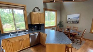 A kitchen with wooden cabinets, a dishwasher, and a large island. - Luxury Cabin in Recreation Paradise! Close to everything: Nature, Food, Suncadia (Cle Elum)