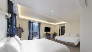 A hotel room with two beds, a desk with chairs, a TV, and a view of the city through a large window. - BONATREE HOTEL (Busan)