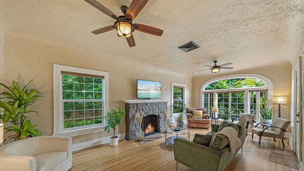 A spacious living room with a fireplace, large windows, and ceiling fans. - 3/2 Luxury Spanish Villa - Pool - Pet Friendly (Lakeland)