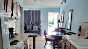 A kitchen with wooden cabinets, a dining table with chairs, a ceiling fan, and a view to the outside. - This is a great vacation home with oceans views  (George Town)