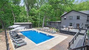 A swimming pool with lounge chairs, a covered seating area, and a deck. - The Neighborhood Hotel Grand Beach Suite 9 - Two Bedroom (Grand Beach)