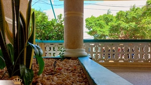 A hotel lobby with a decorative column, a potted plant, and a patterned fence. - Hotel Nueva Esperanza (Barranquilla)