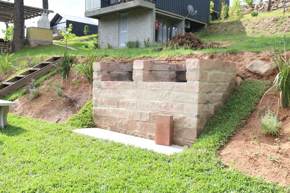 A stone retaining wall with a built-in bench and a small planter. - Cappio Pousada e Lazer Ltda (Bento Gonçalves)