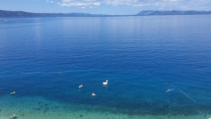 On aperçoit clairement une vaste étendue d’eau, avec une côte lointaine et quelques bateaux.