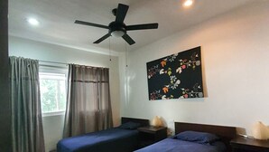 A bedroom with two single beds, a ceiling fan, a window with curtains, and a wall-mounted artwork. - Luxury and Boutique Apartment by Bookhap (Playa del Carmen)