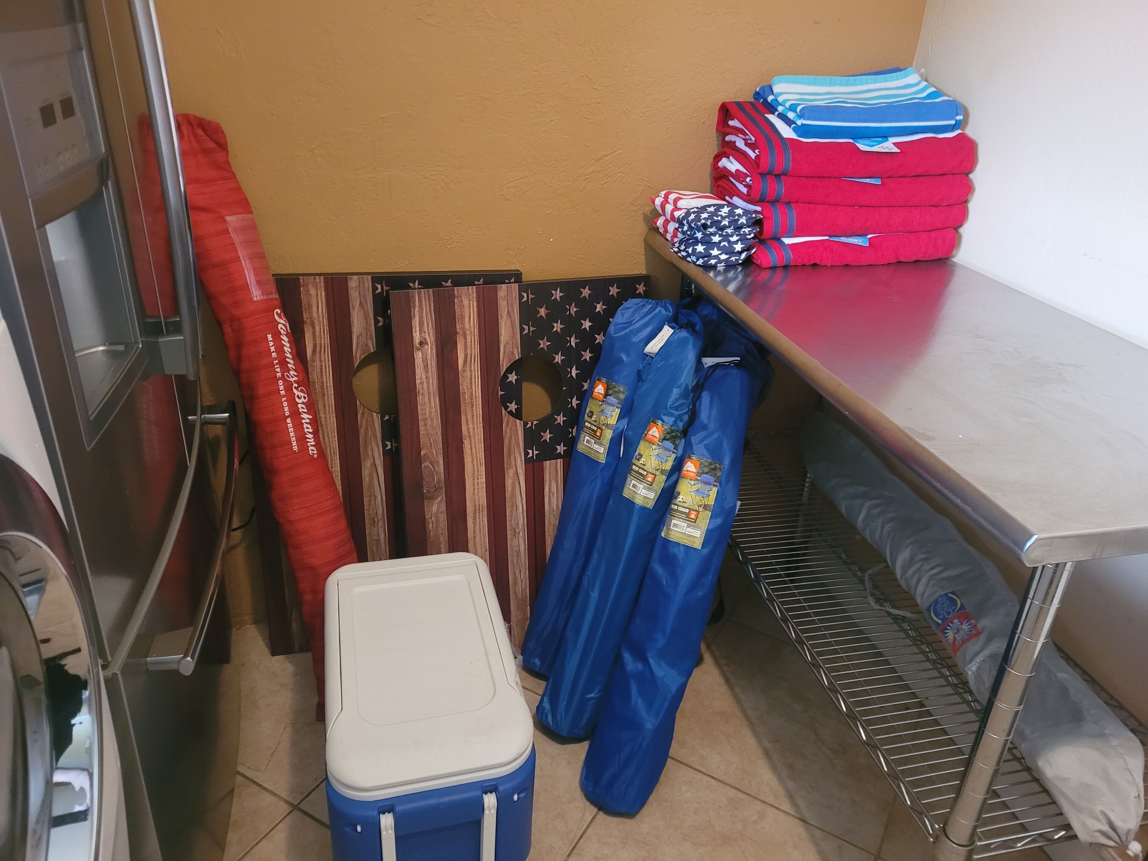A storage area with a cooler, folded clothes, and a bag with a star pattern.