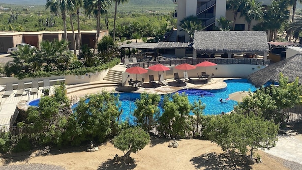 A resort with a swimming pool, lounge chairs, and palm trees. - Authentic 3-story Mexican Villa with Rooftop Views - 5 min from the beach! (El Pescadero)