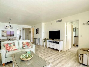 Uma sala de estar moderna com sofá, mesa de centro e televisão de tela plana.