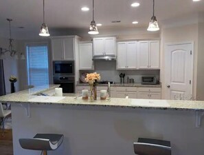Enjoy cooking and socializing in this kitchen with a central island and bar stools.
