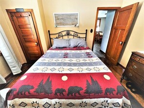 A bedroom with a bed, a wall-mounted sign, and a door. - Lakeview Retreat, Lakeside on the Flowage (Butternut)