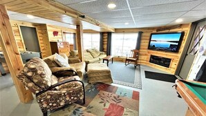 A cozy indoor space with a pool table, comfortable seating, and a television mounted on the wall. - Lakeview Retreat, Lakeside on the Flowage (Butternut)