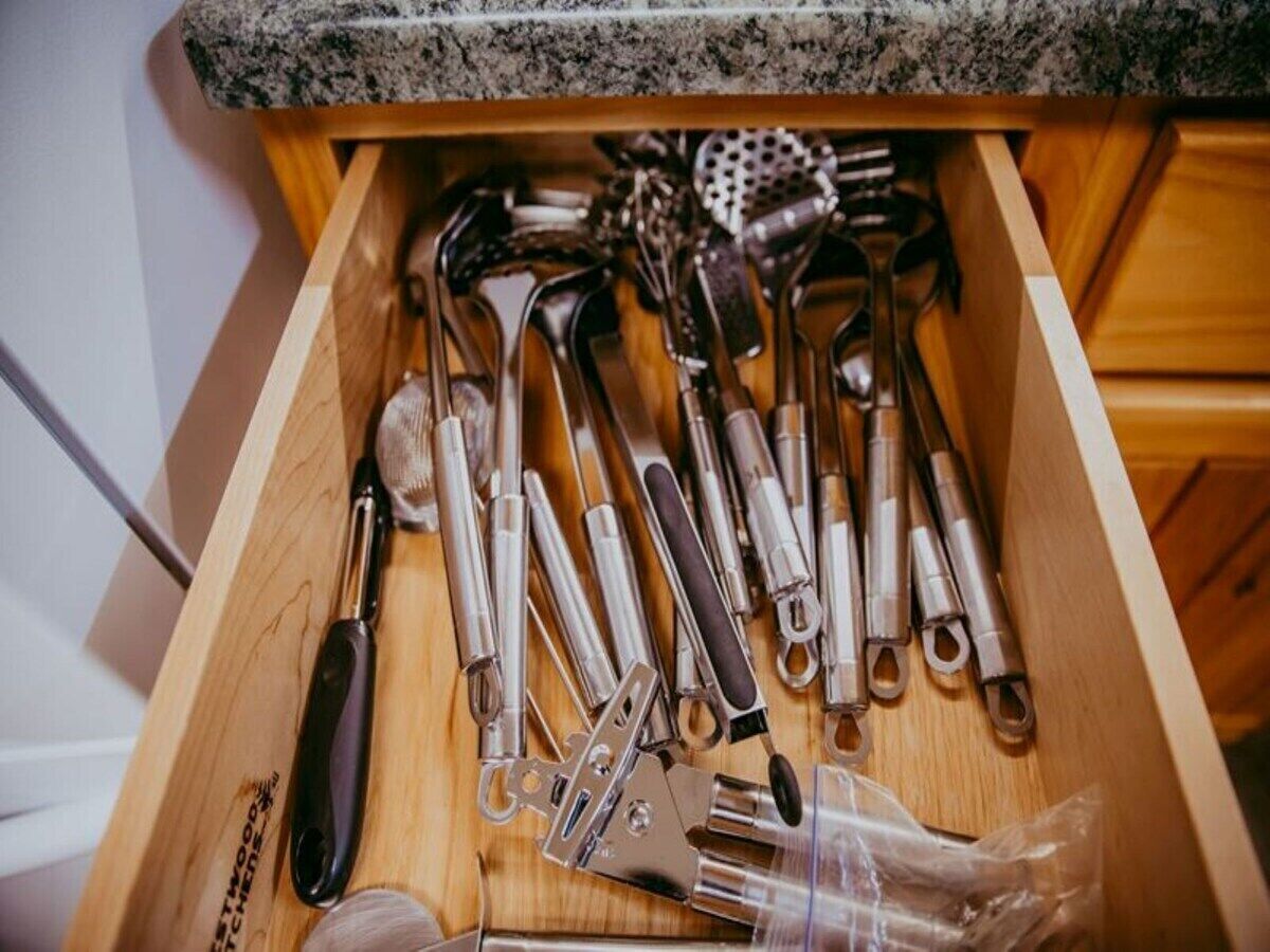 A drawer filled with various kitchen utensils, including spoons, spatulas, and tongs.