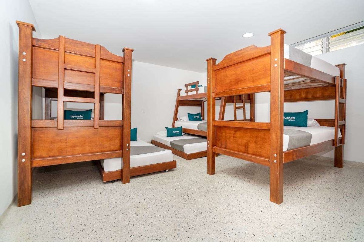 Tres camas literas de madera con cajones de almacenamiento y almohadas con la etiqueta 'ayenda'.