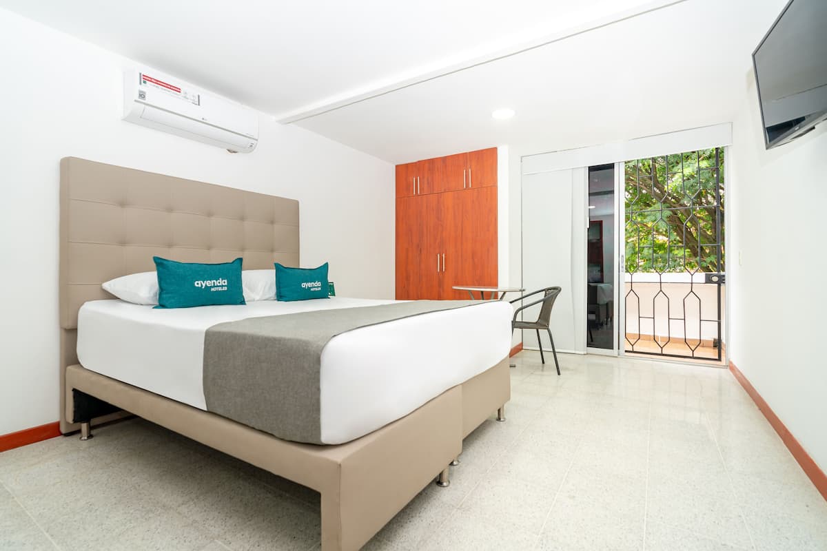 Una habitación de hotel moderna con una cama, un escritorio y un armario.