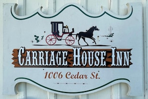 Schild für Carriage House Inn mit einer Illustration von Pferd und Kutsche.