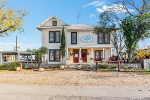 A two-story house with a porch, a sign indicating it's a house inn, and a mailbox. - Carriage Inn - Bandera Suite 2 (Bandera)