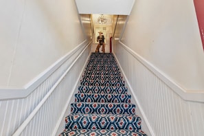 A staircase with patterned carpet and white railings.