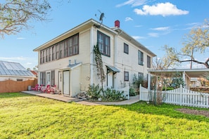 A two-story house with a front porch, a garage, and a fenced yard.