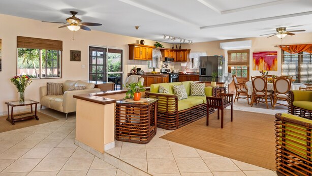 A spacious living area with a sofa, coffee table, and dining set.