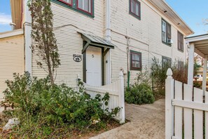 A two-story building with a white exterior, a front door marked with the number 5, and a small porch.