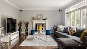 Un salon moderne avec une cheminée, un canapé et un téléviseur.
