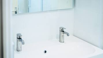 Een douche, een haardroger, handdoeken, toiletpapier