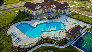 Une grande maison dotée d’une piscine, d’un court de tennis et d’une pelouse bien entretenue.