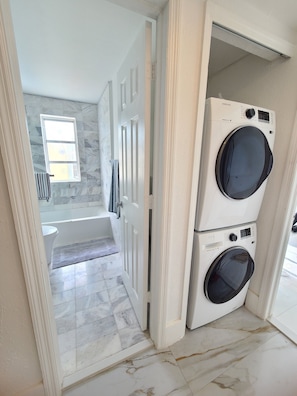 Tina con regadera, jabón, papel de baño