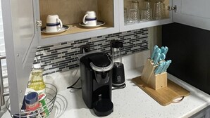 A kitchen with a coffee maker, a blender, and a knife block on the counter.