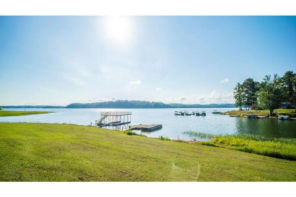 Una zona verde junto al lago con un muelle y barcos.