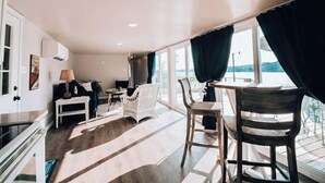 A modern interior with a sofa, chairs, a small table, and a window with curtains. - Douglas Lake -LakeFRONT home w/ Dock (Dandridge)