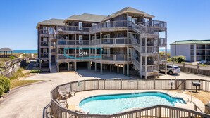 A multi-story wooden building with balconies and a swimming pool. - Sand Flee: Oceanfront condo, first level, awesome ocean views, community pool (Kill Devil Hills)