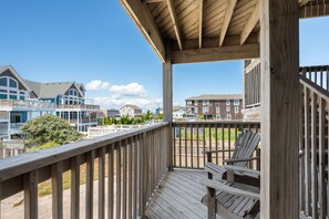 A wooden deck with a view of residential buildings. - Sand Flee: Oceanfront condo, first level, awesome ocean views, community pool (Kill Devil Hills)