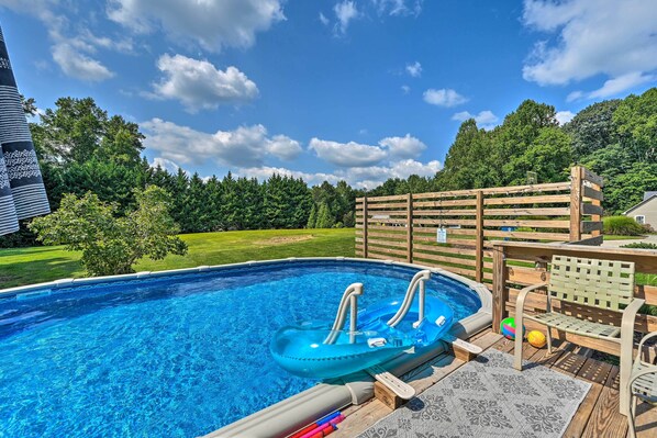 A swimming pool with a hot tub, surrounded by a wooden deck and a wooden fence. - Peaceful Country Retreat w/ Easy Highway Access! (Browns Summit)