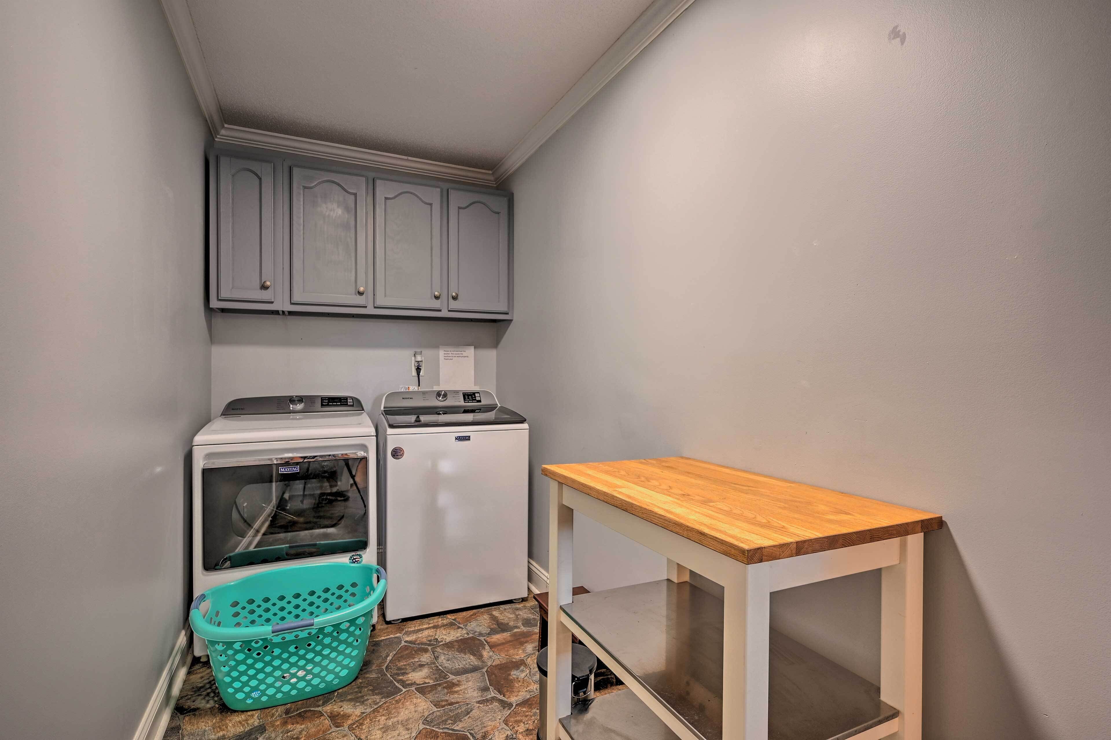 Un espace buanderie comprenant un lave-linge, un sèche-linge et une petite table.