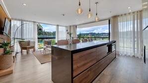 Una cocina moderna con una isla central, ventanas amplias y vistas al exterior.