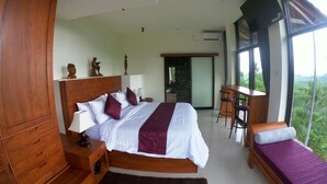 A bedroom with a large bed, a wooden wardrobe, a desk with a chair, and a view of the outdoors. - A Romantic Gateaway Villa With The Best View Of Bali (Kabupaten Karangasem)