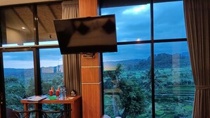 A room with a large window, a TV, a desk with a chair, and a bed. - A Romantic Gateaway Villa With The Best View Of Bali (Kabupaten Karangasem)