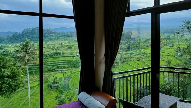 A room with a large window overlooking a lush green landscape with terraced fields and a mountain in the distance. - A Romantic Gateaway Villa With The Best View Of Bali (Kabupaten Karangasem)
