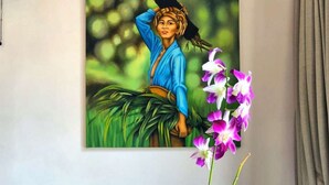 Une pièce avec un canapé bleu, un vase blanc contenant une plante et deux noix de coco.