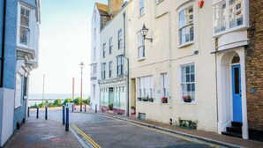 A narrow street with buildings on either side, a clear sky, and a visible horizon. - Elizabeth | Seaside charm | Iconic location (Ramsgate)