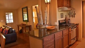 A kitchen with wooden cabinets, a stove, and a countertop. - Desert Oasis & Spa - 30 Night Rental - Kayenta, Tuacahn & Zion  (Ivins)