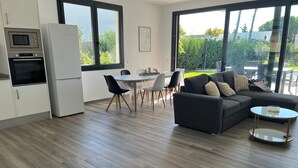 Un espacio de estar moderno con cocina, comedor y zona de descanso.