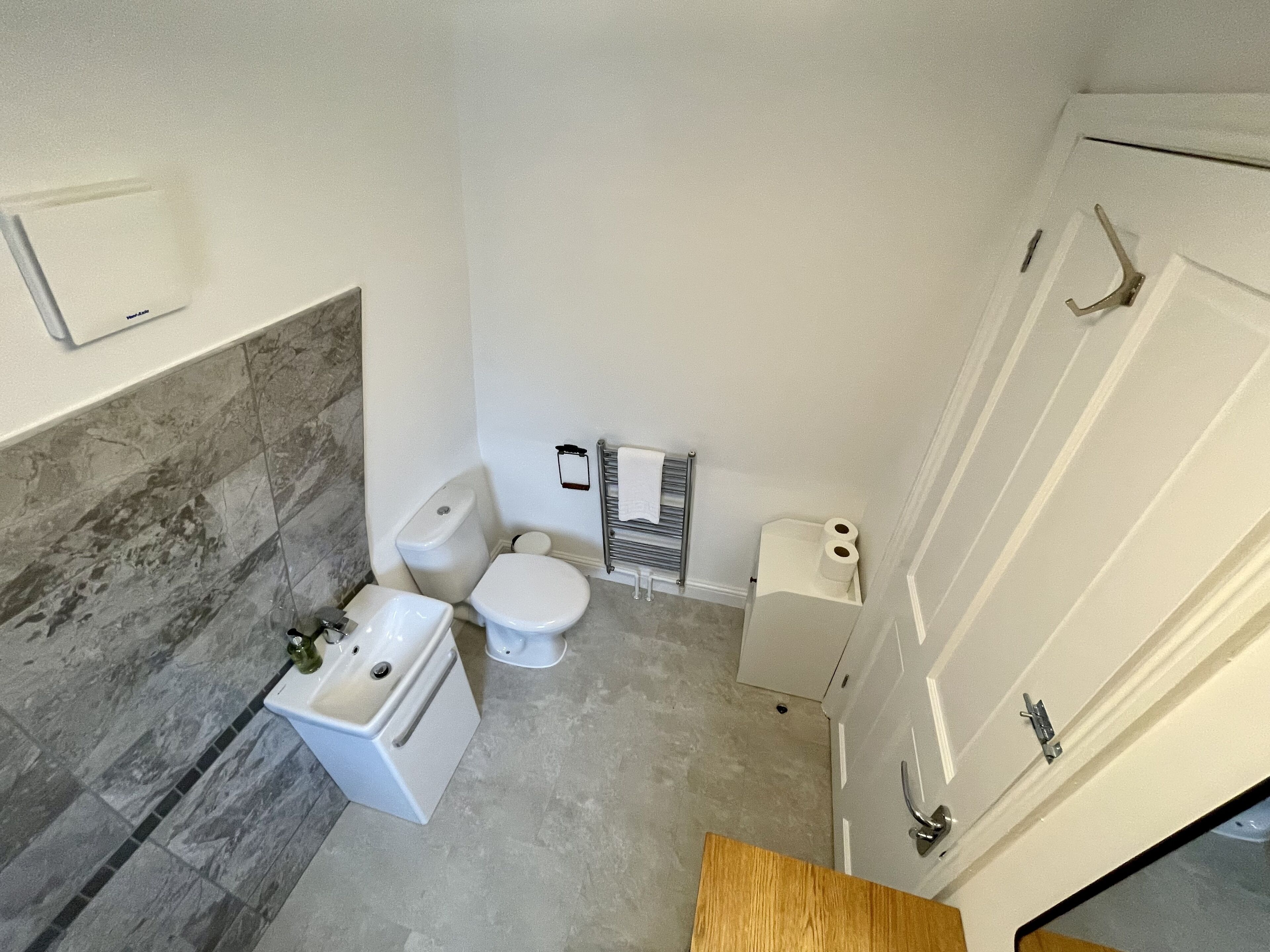 A compact bathroom with a toilet, sink, and shower area.