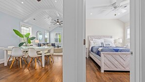 Una habitación con cama, escritorio, sillas y un ventilador de techo.