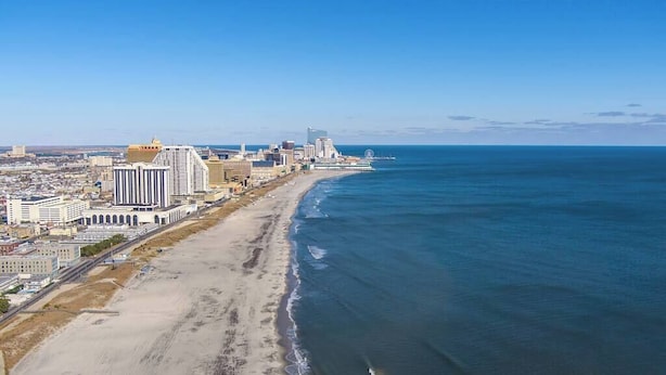 A coastal cityscape with a wide beach, high-rise buildings, and a clear blue sky. - Vibrant AC Loft w/ Beach Views, Sauna, Jacuzzi Tub (Atlantic City)