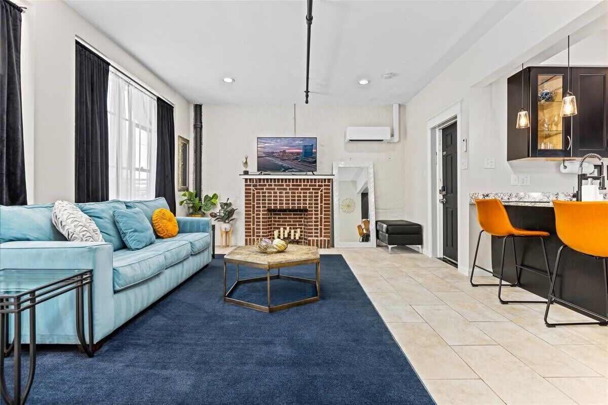 A modern living room with a blue sofa, a coffee table, and a fireplace.