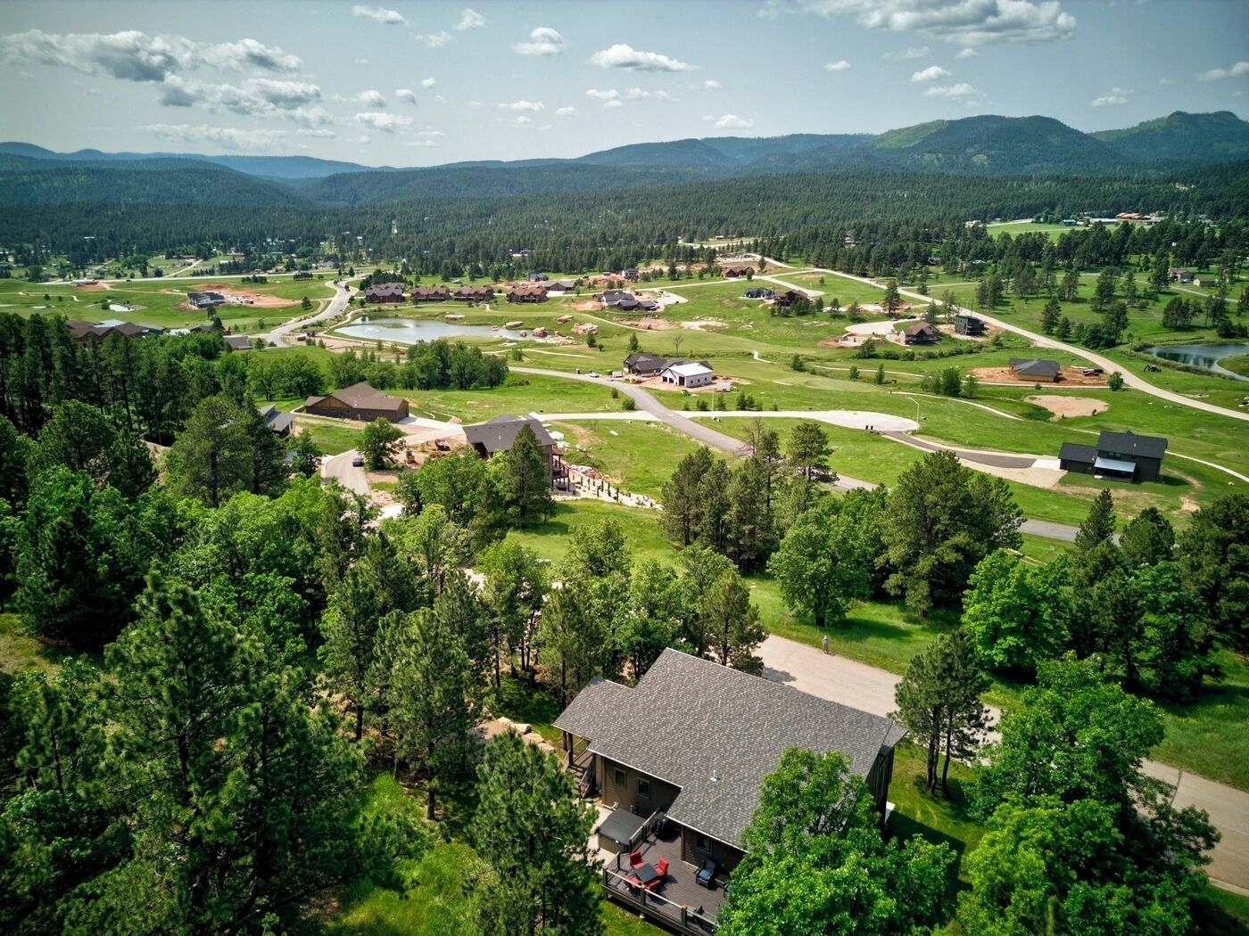 An aerial view of a residential area with houses, roads, and a lake.