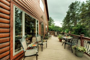A wooden cabin with a deck featuring outdoor furniture and potted plants. - Birdcage- within minutes of downtown Deadwood (Deadwood)