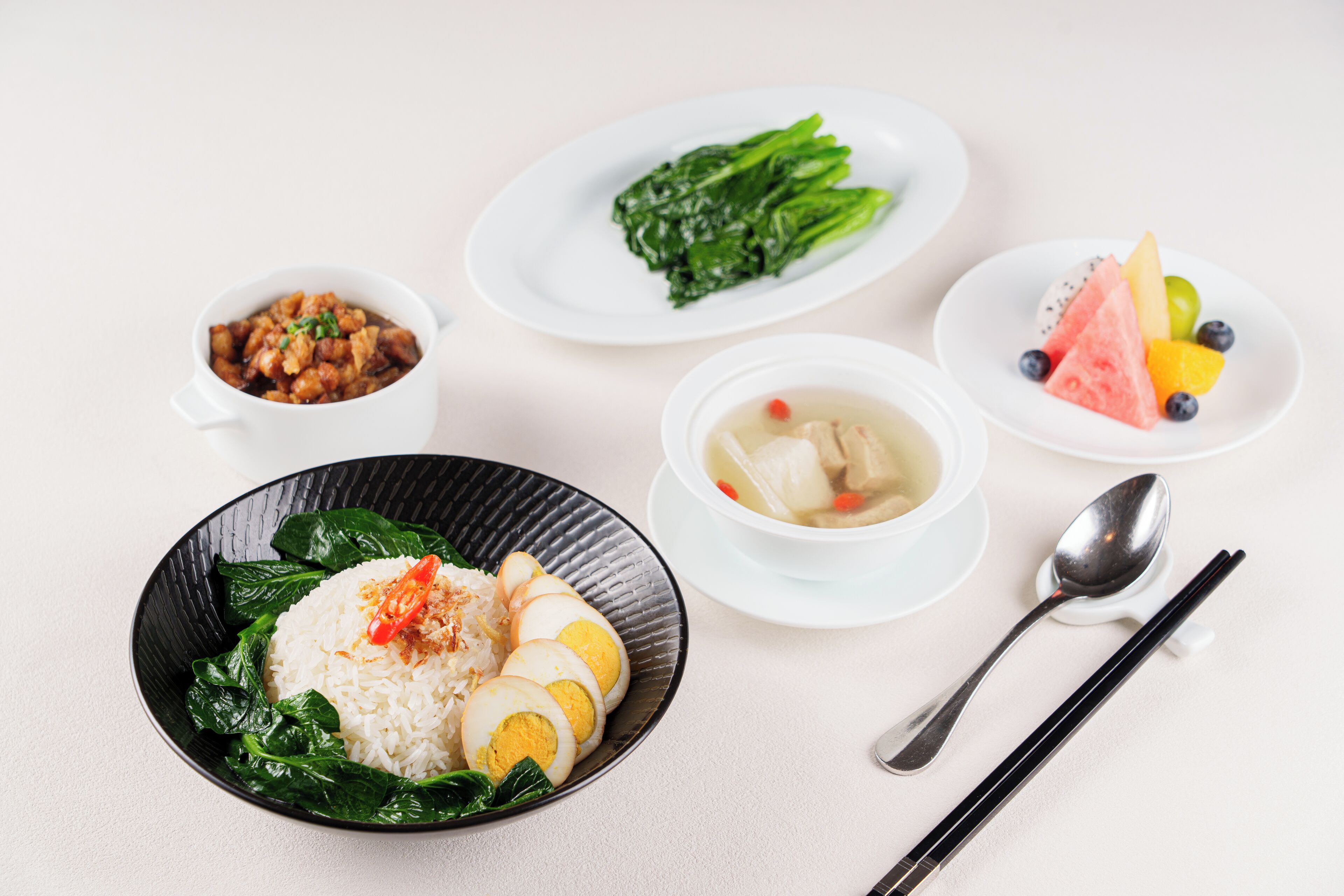 A table with various dishes including rice, soup, and vegetables.
